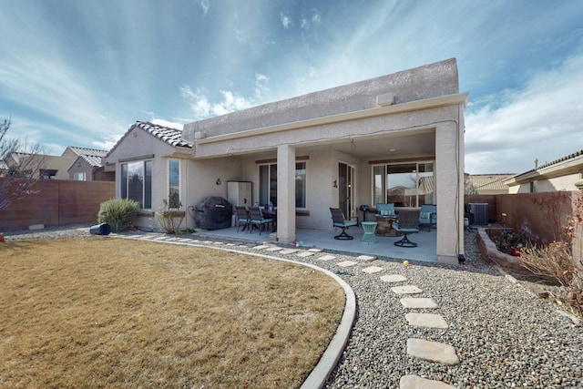 back of property featuring central AC unit, a fenced backyard, stucco siding, a tiled roof, and a patio area