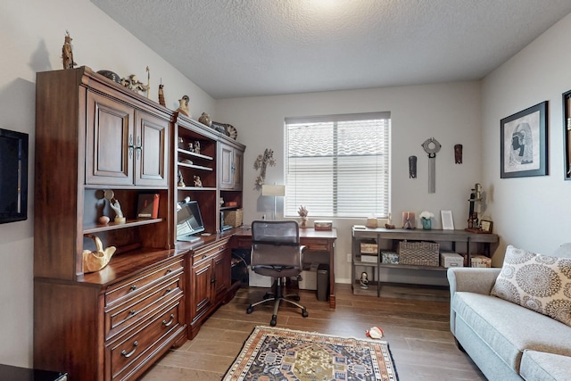 office with a textured ceiling and light wood-type flooring