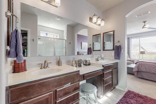 ensuite bathroom with a sink, visible vents, a shower stall, and tile patterned floors