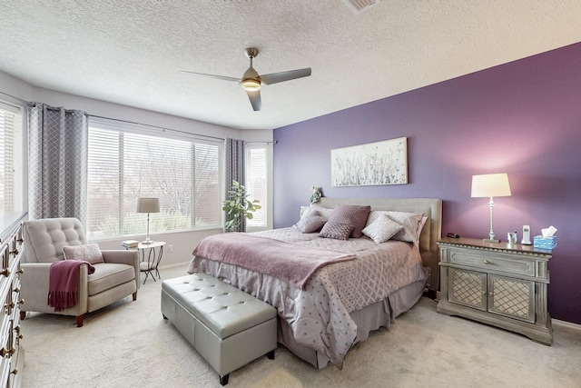 bedroom with light colored carpet, ceiling fan, baseboards, and multiple windows