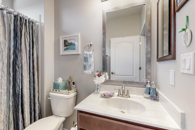 bathroom featuring curtained shower, toilet, and vanity