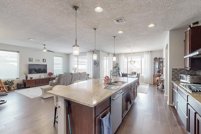 kitchen featuring visible vents, decorative backsplash, appliances with stainless steel finishes, dark wood-style floors, and a sink