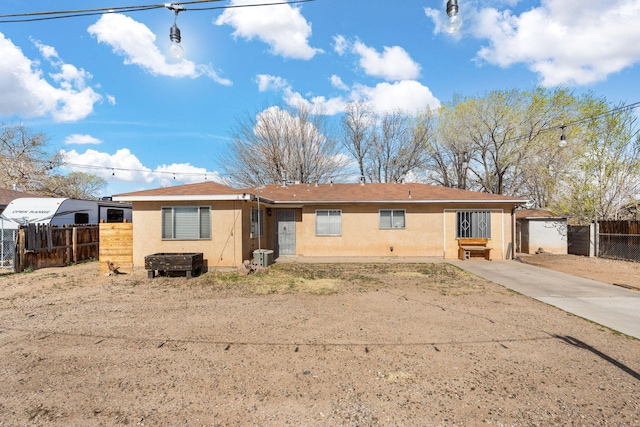 ranch-style house with central AC, fence, driveway, and stucco siding