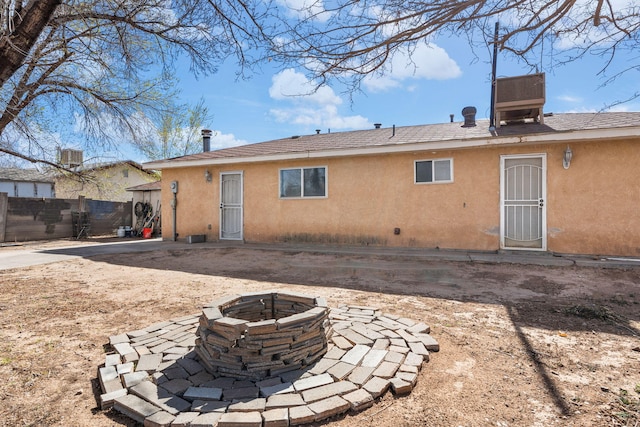 back of property with a patio, an outdoor fire pit, fence, and stucco siding