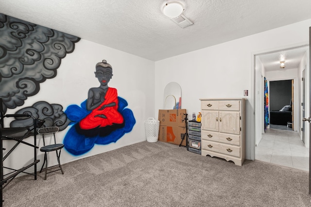 bedroom with visible vents, carpet floors, and a textured ceiling