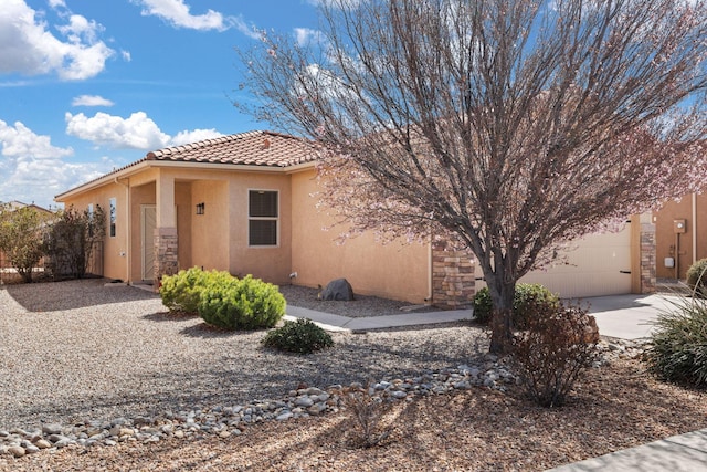 view of front of property featuring stucco siding, a garage, concrete driveway, and a tiled roof