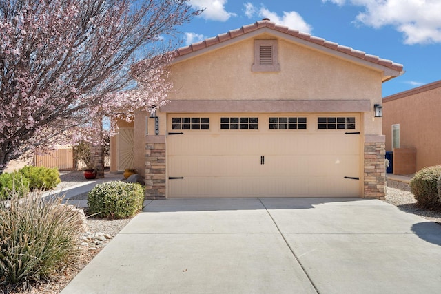 view of front facade with stucco siding, stone siding, an attached garage, and driveway