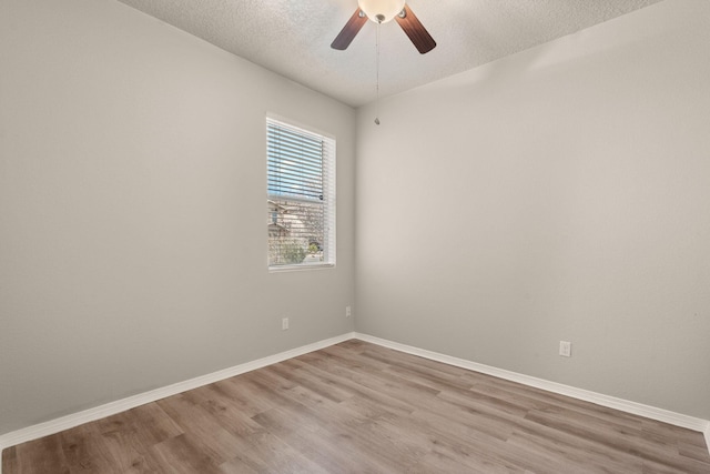 unfurnished room featuring baseboards, a textured ceiling, wood finished floors, and a ceiling fan