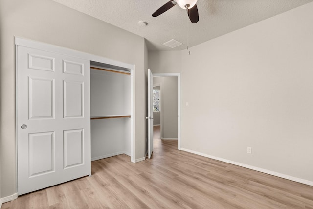 unfurnished bedroom featuring a ceiling fan, baseboards, light wood finished floors, a closet, and a textured ceiling