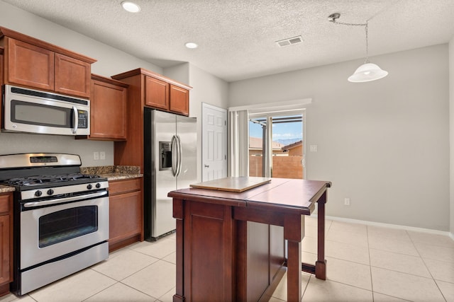 kitchen featuring brown cabinets, light tile patterned flooring, visible vents, and stainless steel appliances