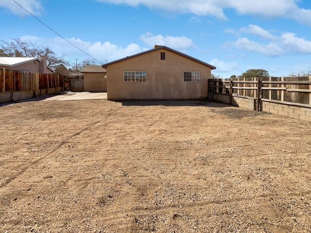 view of side of home featuring a fenced backyard, stucco siding, and a patio