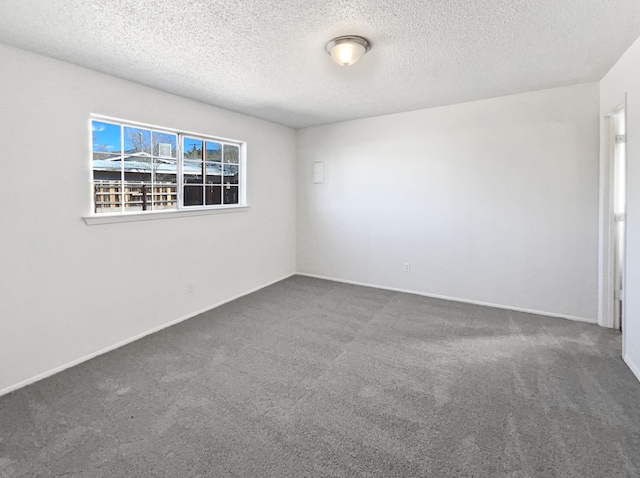 unfurnished room with baseboards, carpet floors, and a textured ceiling