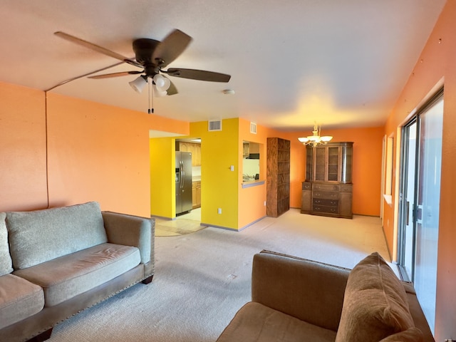 living room with baseboards, ceiling fan with notable chandelier, visible vents, and light carpet