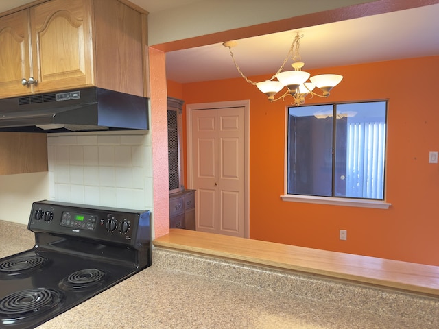 kitchen featuring backsplash, black range with electric cooktop, under cabinet range hood, a chandelier, and light countertops