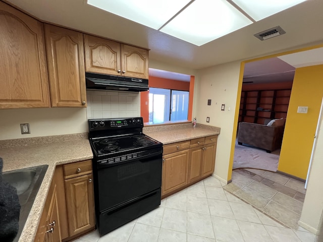 kitchen featuring visible vents, a sink, black range with electric cooktop, under cabinet range hood, and backsplash