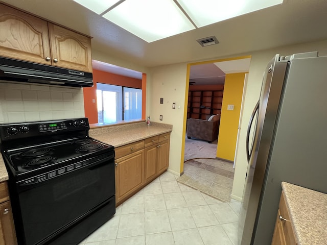 kitchen featuring visible vents, under cabinet range hood, freestanding refrigerator, black / electric stove, and light countertops