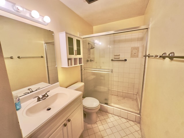 bathroom with vanity, tile patterned floors, toilet, and a stall shower