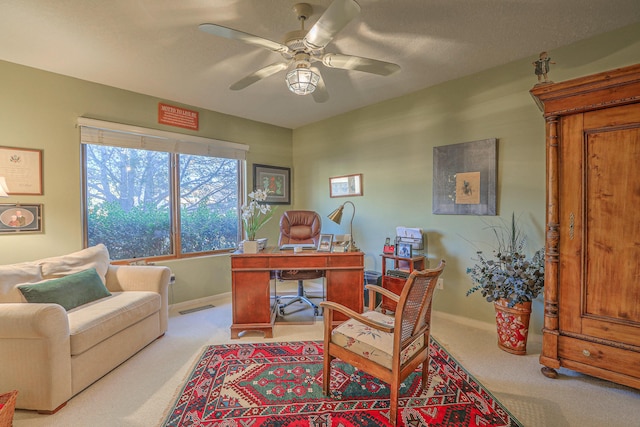 office with visible vents, baseboards, ceiling fan, carpet flooring, and a textured ceiling