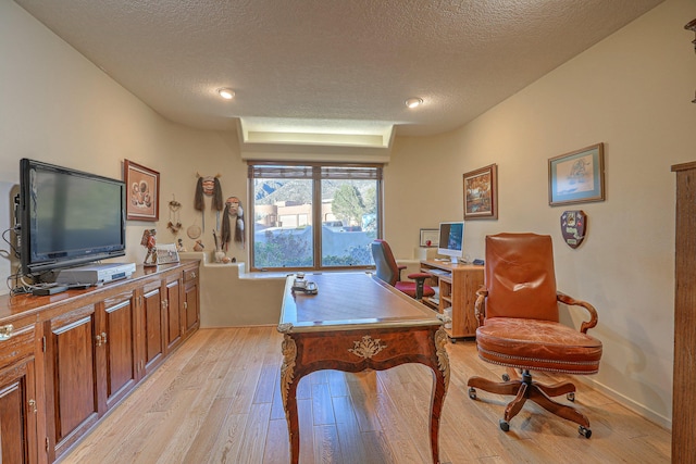 office space featuring light wood-style floors and a textured ceiling