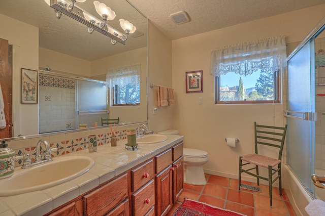 bathroom featuring a healthy amount of sunlight, toilet, and a sink