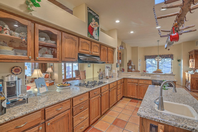 kitchen featuring a sink, under cabinet range hood, a peninsula, and gas stovetop