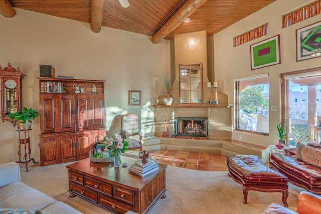 living area featuring beamed ceiling, wood ceiling, carpet floors, and a warm lit fireplace