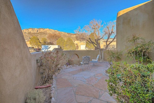 view of patio / terrace featuring fence and a mountain view