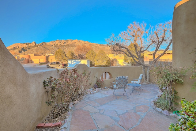 view of patio with a mountain view and fence