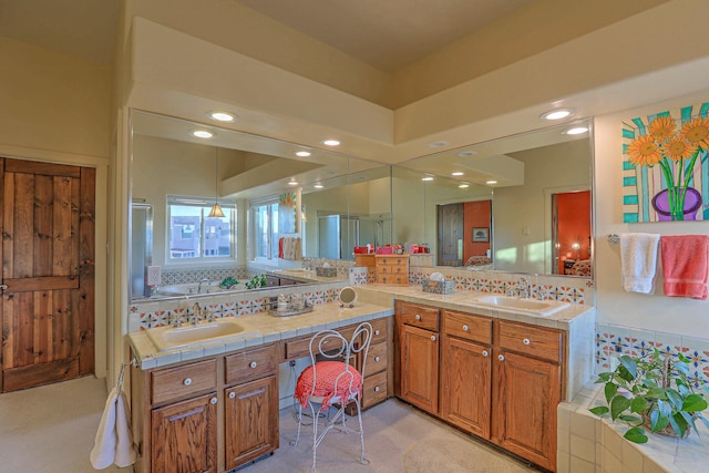 bathroom featuring decorative backsplash, double vanity, recessed lighting, and a sink