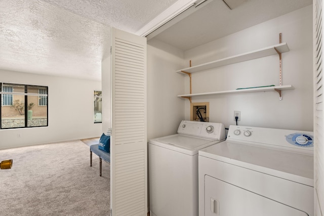 laundry area featuring washer and dryer, carpet, laundry area, and a textured ceiling