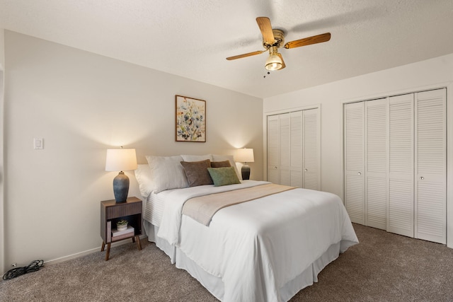 carpeted bedroom with a ceiling fan, baseboards, two closets, and a textured ceiling