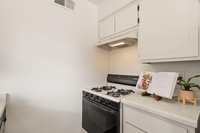 kitchen with visible vents, under cabinet range hood, range with gas stovetop, white cabinets, and light countertops