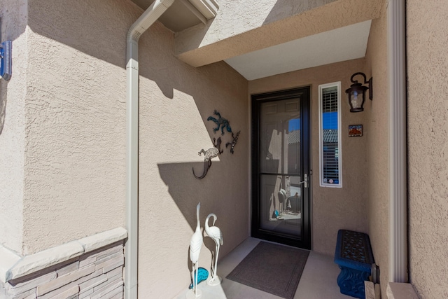 property entrance with stucco siding