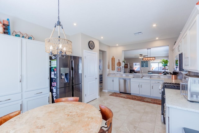 kitchen with visible vents, pendant lighting, a sink, stainless steel appliances, and white cabinets