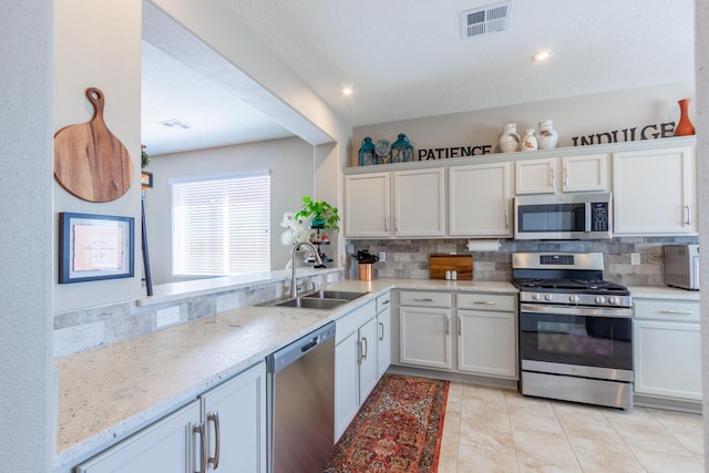 kitchen with visible vents, backsplash, appliances with stainless steel finishes, and a sink