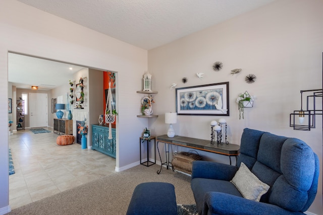 sitting room featuring baseboards, a textured ceiling, and carpet floors