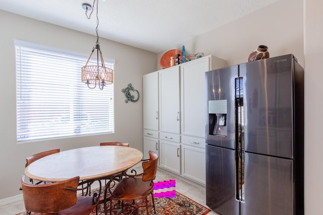 dining area with a chandelier and light tile patterned flooring