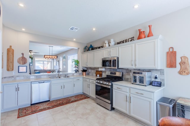 kitchen featuring a sink, stainless steel appliances, visible vents, and decorative backsplash