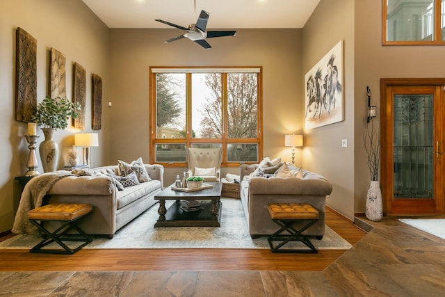 living area with wood finished floors and a ceiling fan