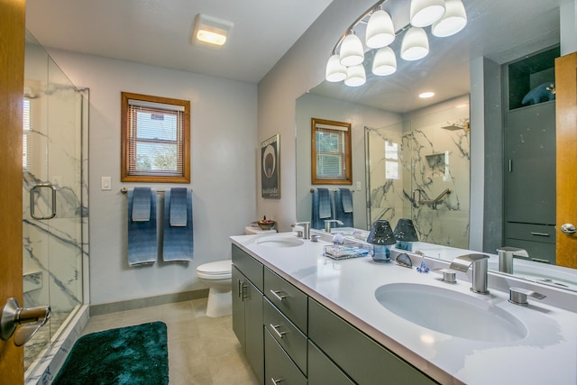 bathroom featuring a sink, a marble finish shower, toilet, and double vanity