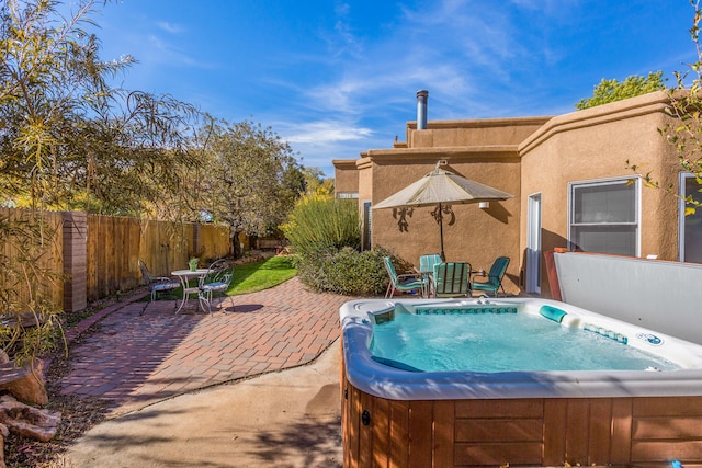 view of patio featuring a hot tub and fence