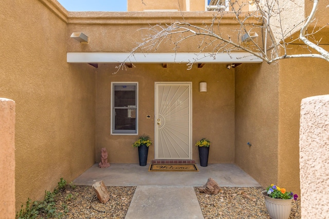 view of exterior entry featuring stucco siding