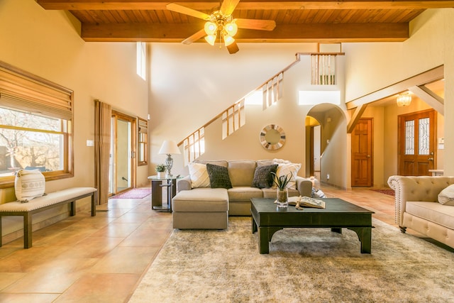 living area with wooden ceiling, beamed ceiling, a ceiling fan, and a wealth of natural light