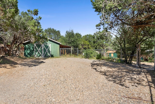 view of yard featuring an outdoor structure and fence