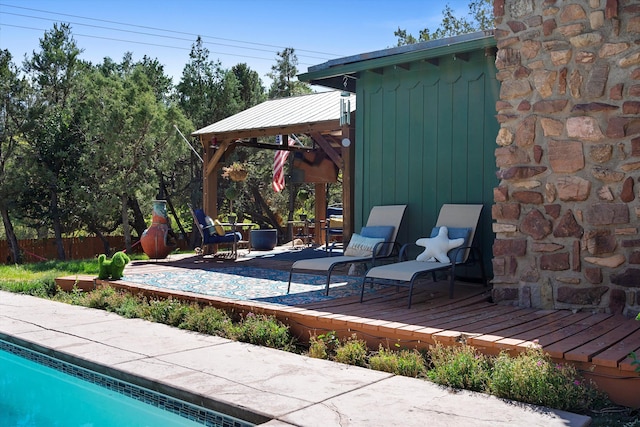 exterior space featuring a gazebo, a fenced in pool, a deck, and fence