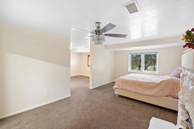 unfurnished bedroom with visible vents, a ceiling fan, a textured ceiling, carpet, and baseboards