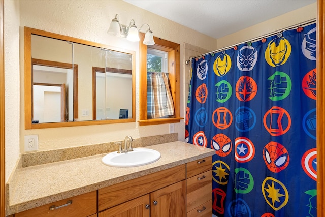 full bathroom featuring vanity, a shower with shower curtain, and a textured wall