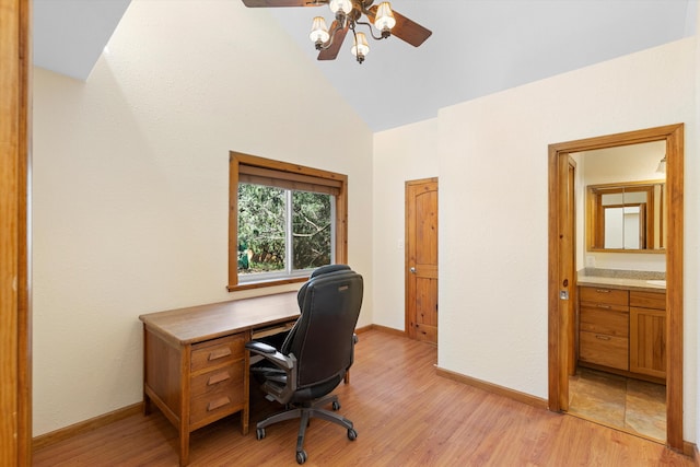 office with baseboards, light wood-style flooring, a ceiling fan, and vaulted ceiling