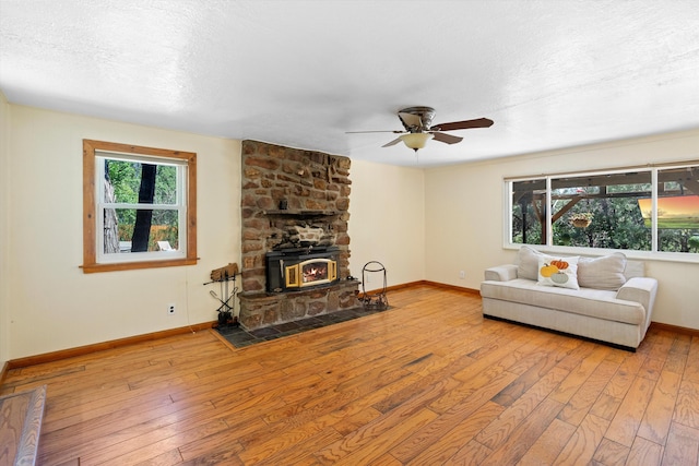 living area with a healthy amount of sunlight, hardwood / wood-style floors, and a ceiling fan