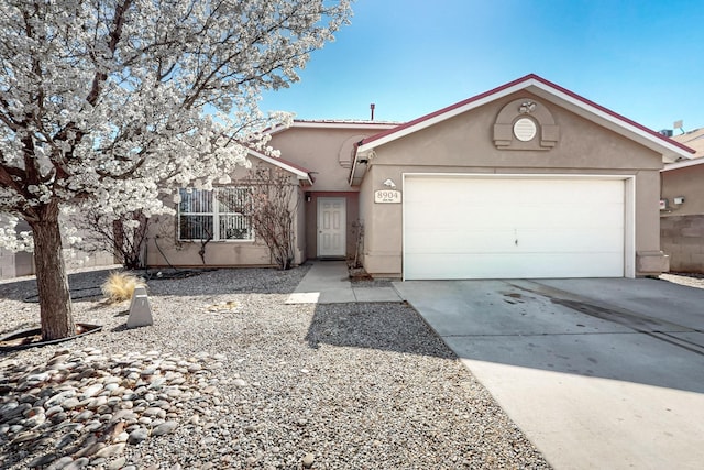 single story home with an attached garage, driveway, and stucco siding